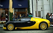 Черно-желтый Bugatti Veyron у летнего кафе